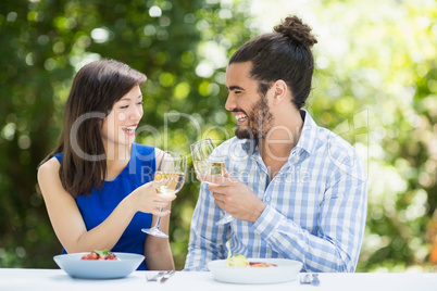 Couple toasting glasses of wine in a restaurant