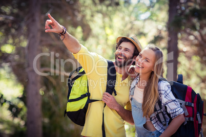 Couple pointing upwards in the forest