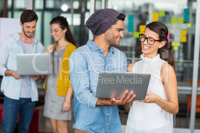 Smiling executives using laptop