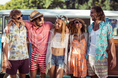 Group of happy friends standing together near campervan