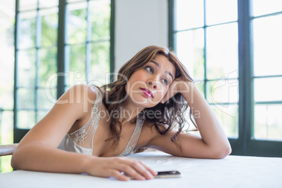 Beautiful woman with mobile phone resting on her elbow
