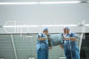 Low angle view of surgeons discussing x-ray in corridor