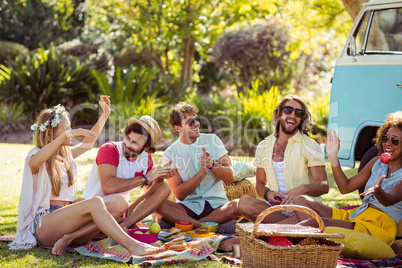 Group of friends having fun together near campervan