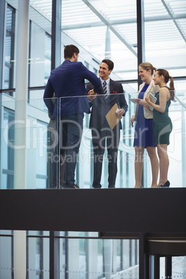 Business executives shaking hands in the corridor
