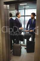 Businessmen interacting with each other in elevator