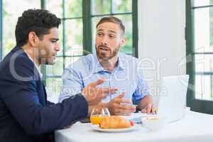 Businessman and colleague using laptop