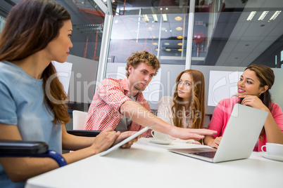 Executives discussing over laptop in conference room