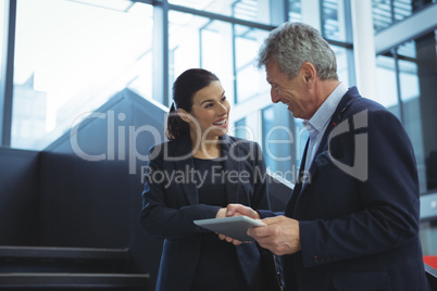 Business executives discussing over digital tablet on stairs