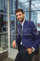 Portrait of handsome businessman standing in corridor