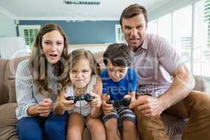 Happy family playing video games together in living room