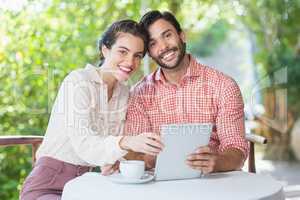 Couple smiling while using digital tablet in the restaurant