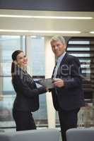 Business executives standing while holding a clipboard