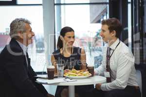 Businesspeople interacting while having breakfast