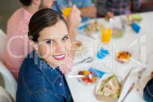 Portrait of happy female executive having breakfast