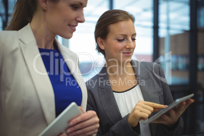 Business executives discussing over digital tablet