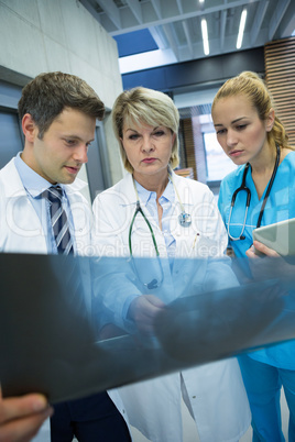 Medical team examining x-ray report in corridor