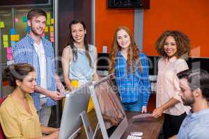 Smiling graphic designers working at desk in office