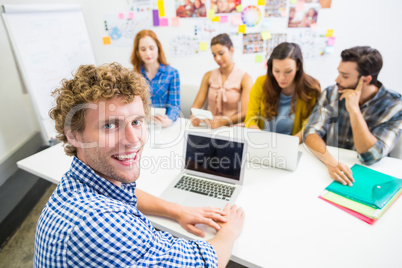 Executive discussing over laptop with his colleagues during meeting