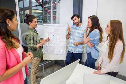 Team of executives having discussion over flip chart