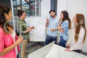 Team of executives having discussion over flip chart