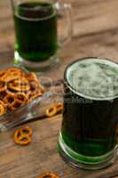 St Patricks Day two mugs of green beer with pretzel