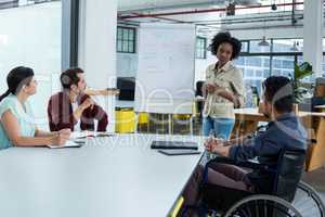 Business executives discussing over flip chart during meeting