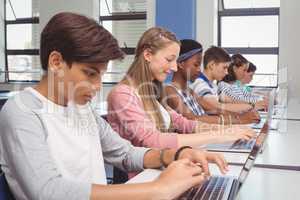 Students using laptop in classroom