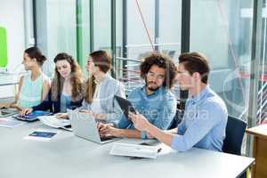 Business team working on laptop and digital tablet in meeting