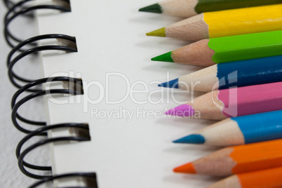 Close-up of colored pencils and notebook