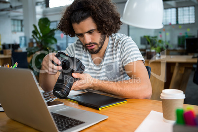 Graphic designer looking at pictures in digital camera