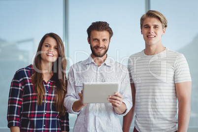 Portrait of smiling business executives using digital tablet