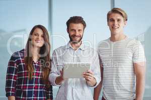 Portrait of smiling business executives using digital tablet