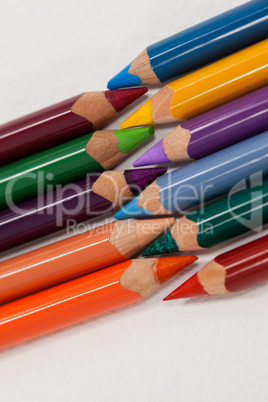 Colored pencils arranged in interlock pattern on white background