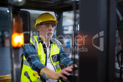 Factory worker driving forklift