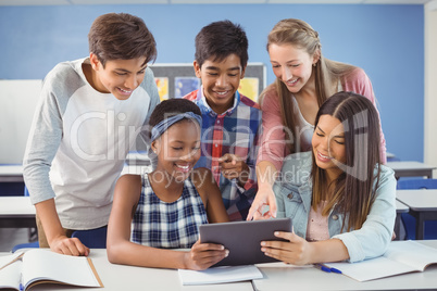 Group of students using digital tablet in classroom