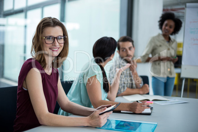 Portrait of smiling business executive using digital tablet in meeting