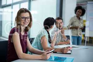 Portrait of smiling business executive using digital tablet in meeting