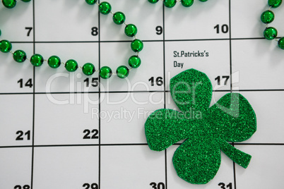 St. Patricks Day shamrock and beads kept on calendar