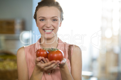 Woman holding tomatoes in grocery store