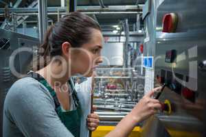 Female factory worker operating machine