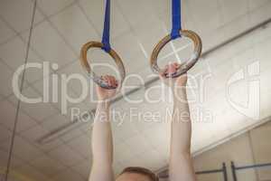 Female gymnast practicing gymnastics on rings