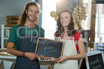 shop assistants holding open sign board