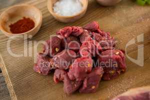 Diced beef and spices on wooden tray