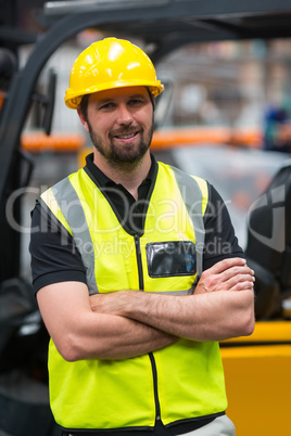 Factory worker standing with arms crossed in factory