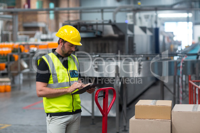 Factory worker using a digital tablet