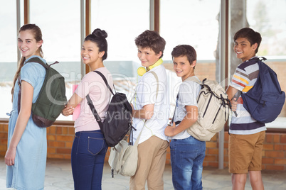 Portrait of happy students standing in corridor