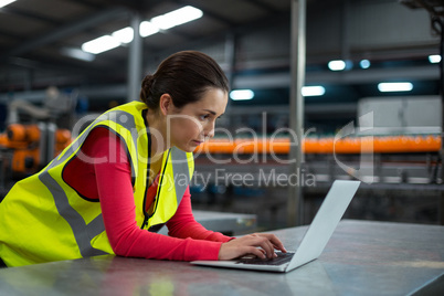 Factory worker using laptop