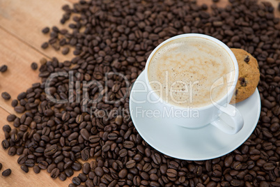 Coffee cup with cookie and coffee beans