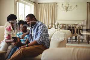 Family using mobile phone in living room