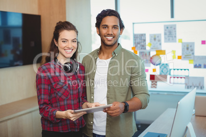 Male and female graphic designers holding digital tablet